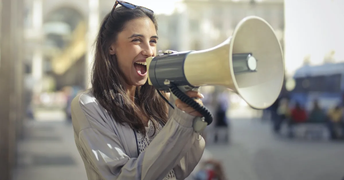 Non-profit marketing by smiling woman using loudspeaker