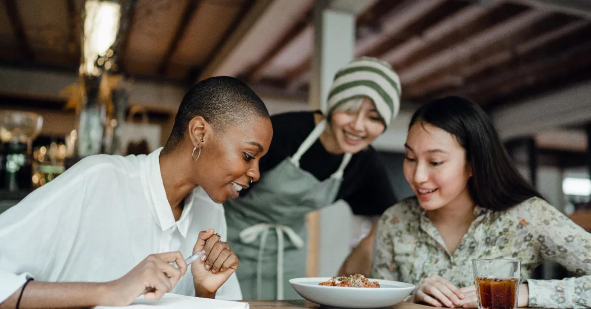 Leads making friends with business owner as they examine served dish